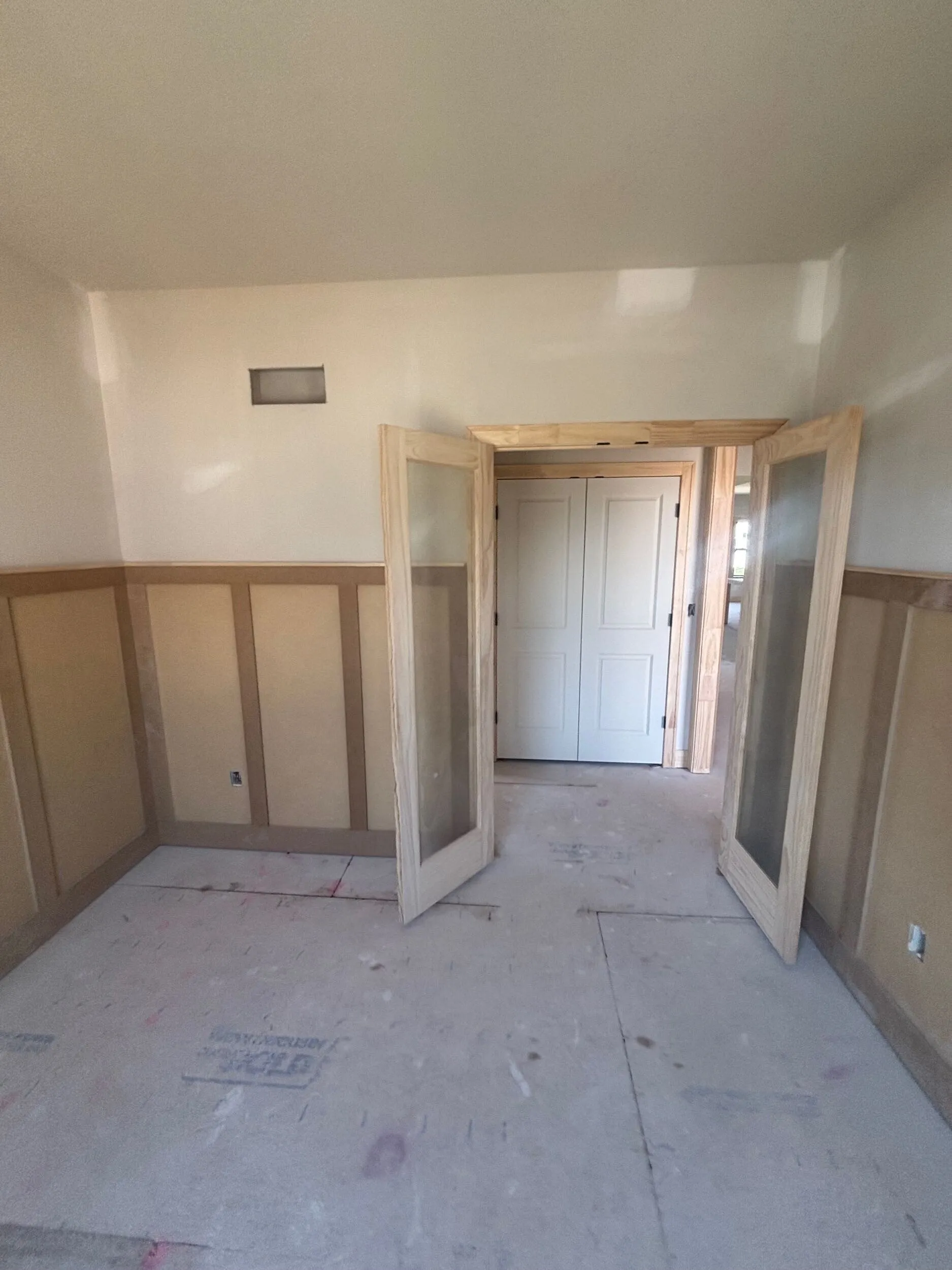 Board-and-batten wainscoting with custom glass french doors and stained trim